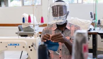 Imigrantes aprendem a produzir máscaras para geração de renda 