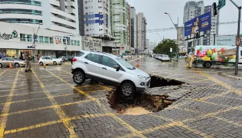 Carro quase cai em cratera que se abriu no centro de Maringá Carro quase cai em cratera que se abriu no centro de Maringá