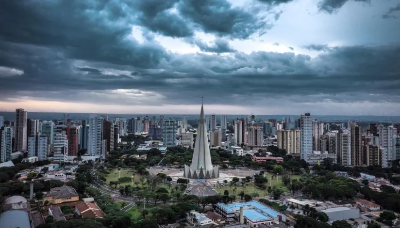 A foto mostra a Catedral de Maringá e toda a região a sua volta com o céu nublado.