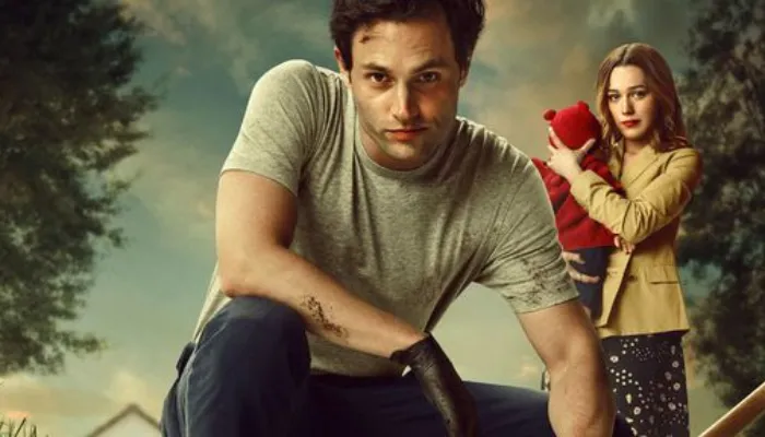 Foto promocional da terceira temporada de You. Em segundo plano Love segura o bebê vestido de vermelho enquanto, em primeiro plano, Joe está agachado com a mão e o rosto sujos de terra olhando para a câmera com um sorriso perverso.
