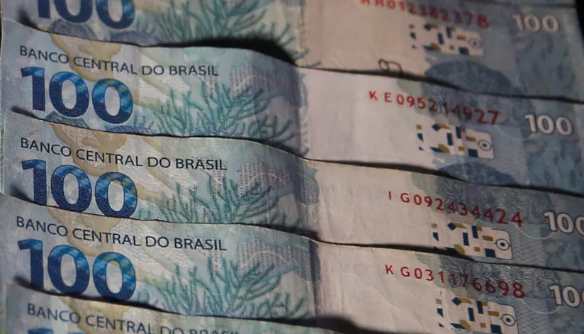 A foto mostra cinco faltas de 100 reais sobrepostas umas às outras.