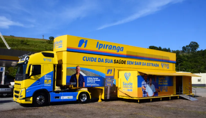 A foto mostra a carreta de saúde do posto Ipiranga, adesivada em azul e amarelo.