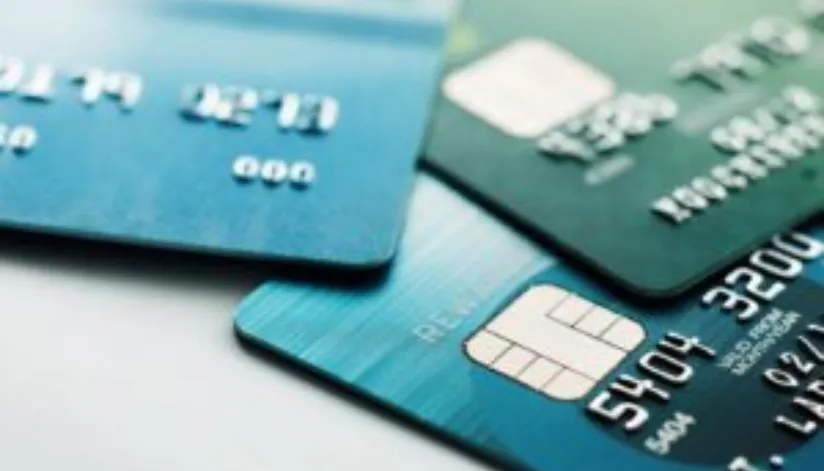 A foto mostra três cartões de crédito sobrepostos.