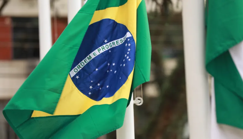 A foto mostra a bandeira do Brasil hasteada.
