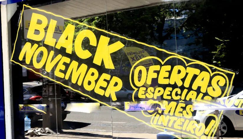 A foto mostra uma vitrine com o texto "Black November: ofertas especiais o mês inteiro!" escrito em amarelo.